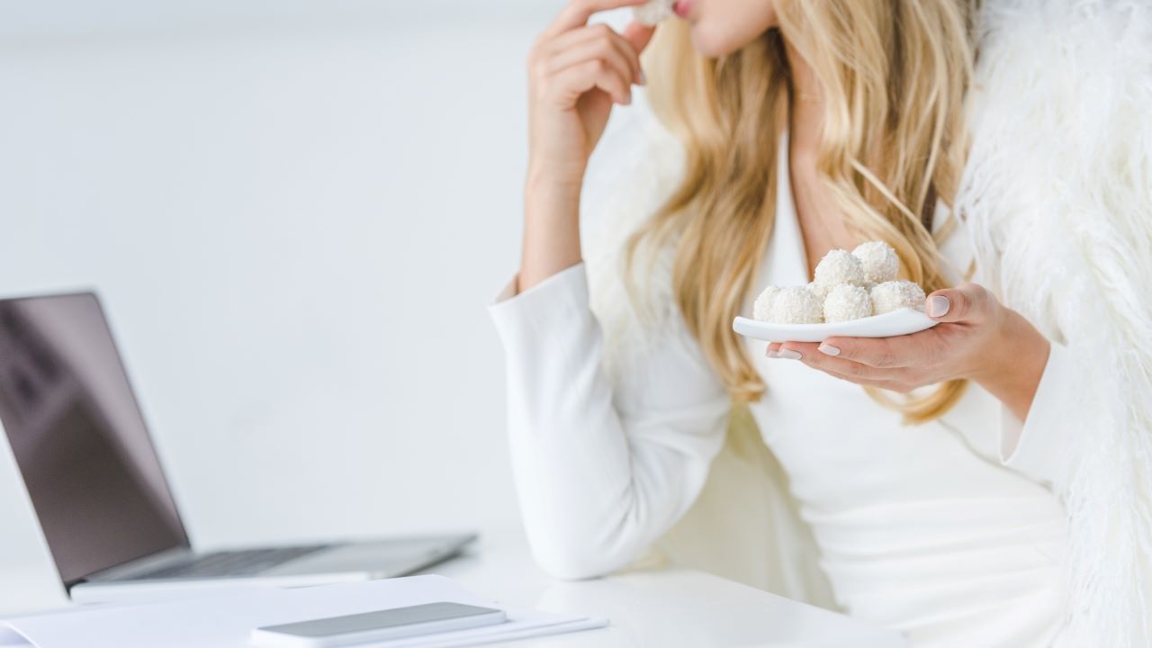 Persona che sta gustando dei dolcetti al cocco 