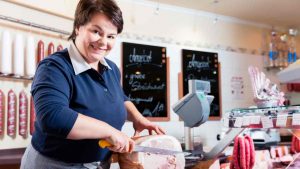 Salumiere che affetta prosciutto cotto